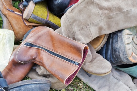 pile of old vintage shoes on the grassの写真素材