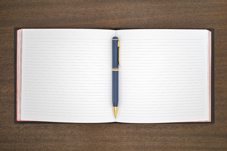 new notebook with pen on the brown wooden tableの写真素材