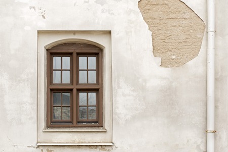 cracked wall with window and rain water pipe