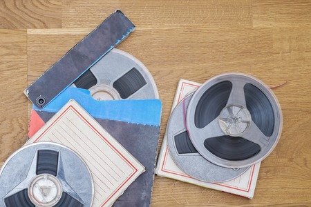 Vintage magnetic audio tapes, reel to reel type, paper box on the grunge wooden floorの写真素材