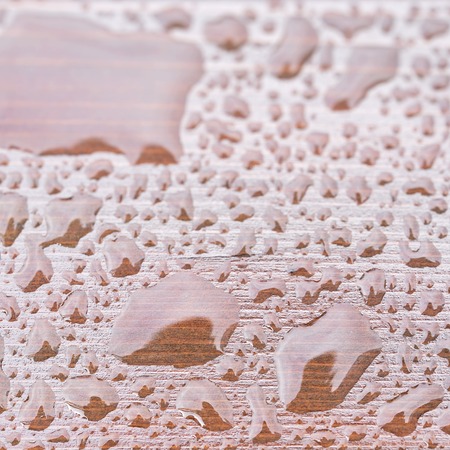 Closeup rain drops on brown wooden backgroundの写真素材