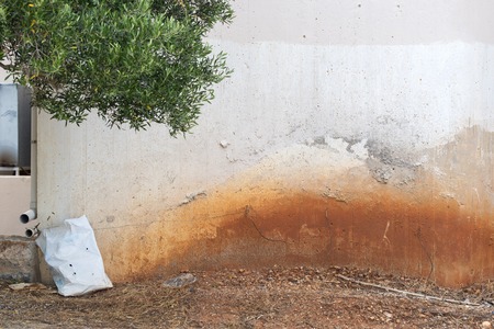 abandoned grunge cracked stucco wall, sandy dirty groundの写真素材