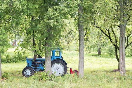 Old Russian rusty blue tractor in the gardenの写真素材