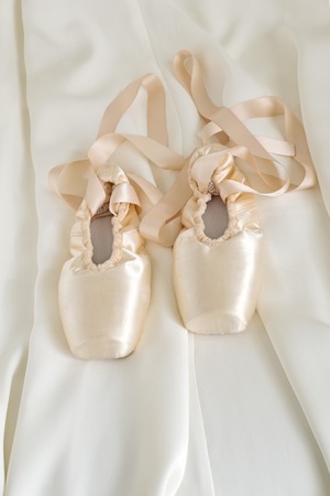 Ballet pointe shoes on beige color fabric backgroundの写真素材