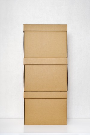 Three cardboard boxes on the white wooden floorの写真素材