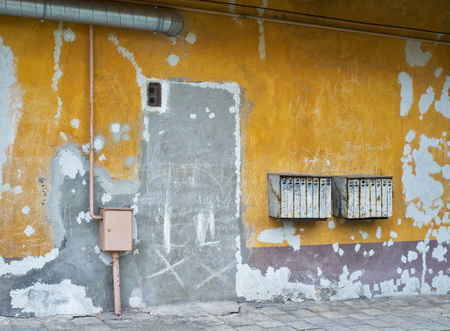 Rusty mailboxes on cracked yellow stucco wallの写真素材