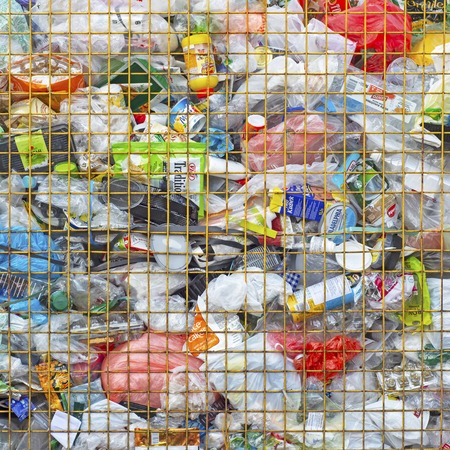 VILNIUS, LITHUANIA - March 25, 2018: Plastic waste in metal wire mesh container. Full of coloful bags, bottles, tetrapaks, cansのeditorial素材