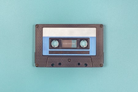 Retro black blue plastic audio cassette tape on green metal backgroundの写真素材