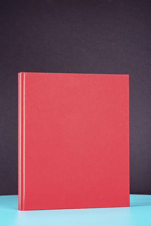 Red book on the green metal table. Black background.の写真素材