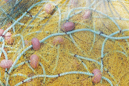 Yellow fishing net drying on the shore. Close up view