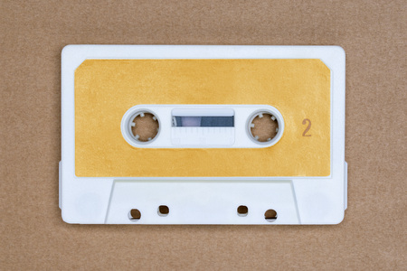 Retro white audio tape with yellow label on brown background. Side 2
