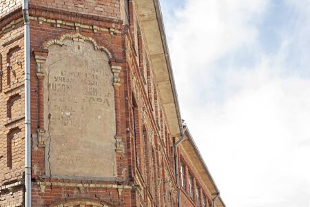 Abandoned grunge cracked red brick building. Big stucco frame on the wall.の写真素材