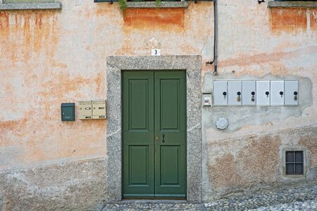 Old weathered grunge house. Green wooden door.の写真素材