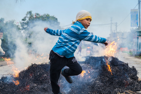 Chinese Men Jumping a block of Fire and Straw for lunar month  festivalのeditorial素材