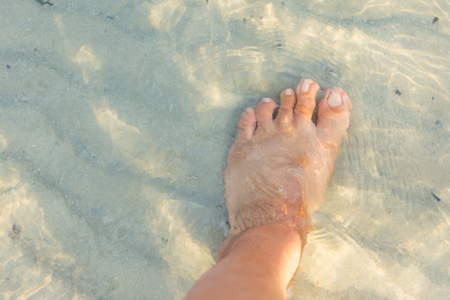Foot in the water by the beachの写真素材