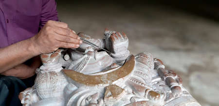 BHUBANESWAR, ODISHA, INDIA,NOVEMBER 2019 - Craftsman hands working on a statueのeditorial素材