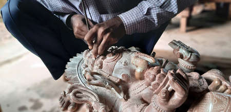 BHUBANESWAR, ODISHA, INDIA,NOVEMBER 2019 - Craftsman hands working on a statueのeditorial素材