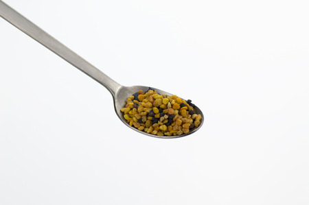 bee pollen grains with spoon on white backgroundの写真素材