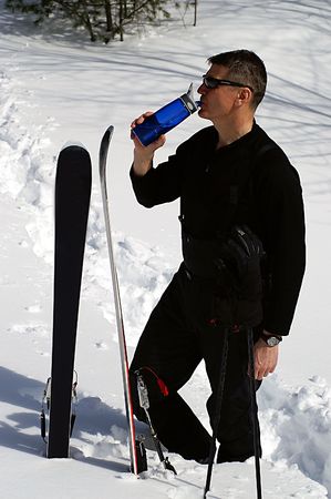 A man drinking water when skiingの写真素材