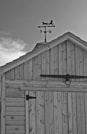 Weather vane and cupola atop a wooden carriage house or garden shedの写真素材