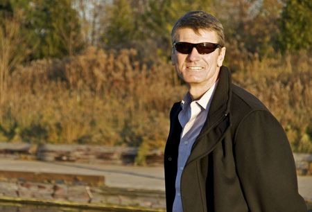 Mature Man with Sunglasses and Overcoatの写真素材