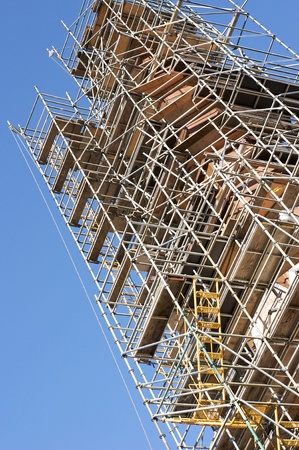 Commercial scaffolding surrounds a church spire under restoration.のeditorial素材