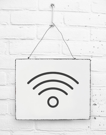 Wifi zone symbol sign on hanging board on white brick wallの写真素材