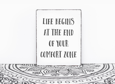 Bohemian vintage carpet travel quote life begins at the end of your comfort zone text on board white isolated wall backgroundの写真素材