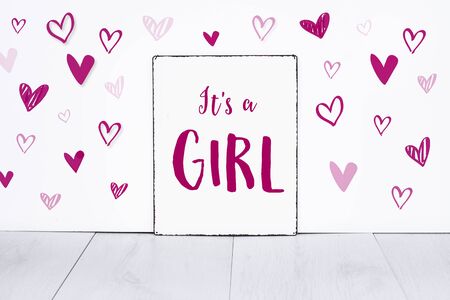 It's a girl new born baby text on sign board with cute little pink hearts on white backgroundの写真素材