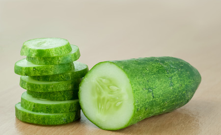 Cucumber half and Slices on wood table backgroundの写真素材