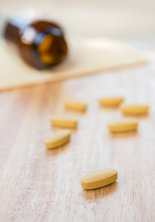 Pills,Vitamin Pills On Light Wood Background Focus on Front Pillsの写真素材