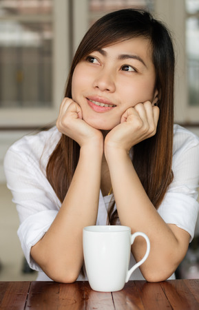 Asian woman smiling happily with drinking coffee in the morning.の写真素材