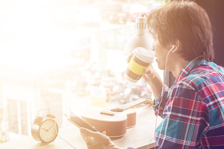 Happy handsome man at cafe drinking coffee and looking out the window,in brake time.の写真素材