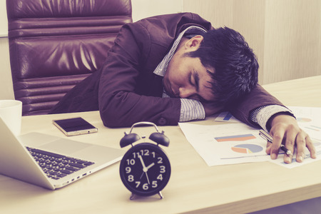 à¸´Businessman sleeping at workdesk.の写真素材