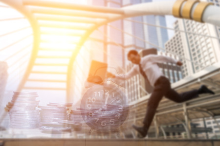Double exposure of blurred office workers go to work late and coins and alam clock in business conceptの写真素材