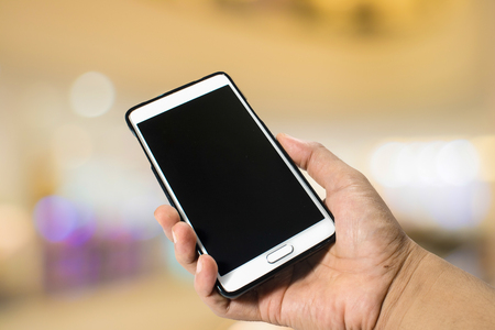 hand hold smartphone on bokeh backgroundの写真素材