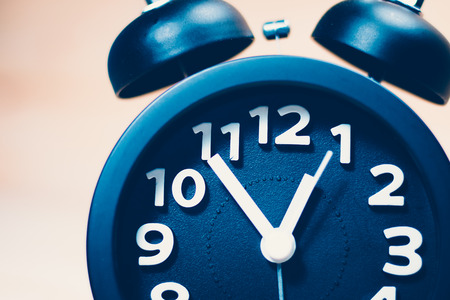 Black alarm clock  on wood background / vintage tone
