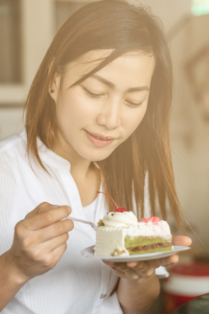 Beautiful woman eating cake happily.の写真素材