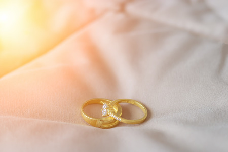 Wedding rings placed on a bed.の写真素材