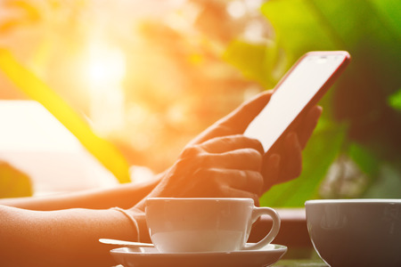 Woman using smart phone in coffee shopの写真素材