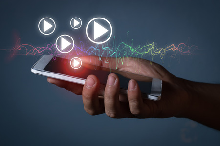 hand hold smartphone with play icon and soundwaveの写真素材