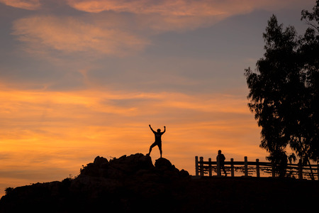 Silhouette of happy people in sunset On the Cliff by the Sea.の写真素材