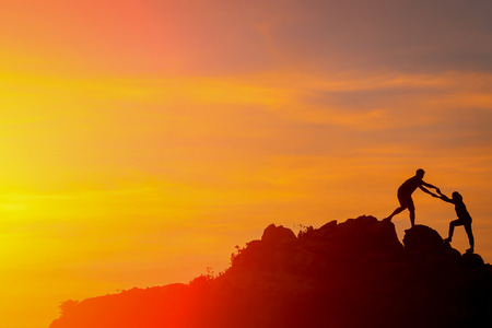 Silhouette of happy people in sunset On the Cliff by the Sea.の写真素材