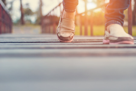 Movement of woman walking on a wooden bridge in the sunset.の写真素材