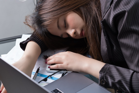 Asian business woman sleep in workdeskの写真素材