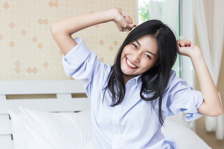 Happy Asian woman in the morning on bedの写真素材