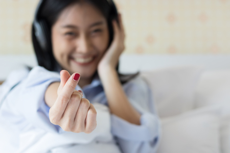 Asian girls are listening happily on the bed.の写真素材
