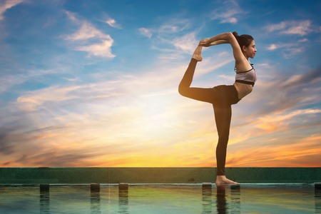 Attractive women are playing yoga. At the pool for her good healthの写真素材