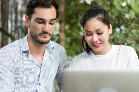Business man and women working in the garden with laptops.の写真素材