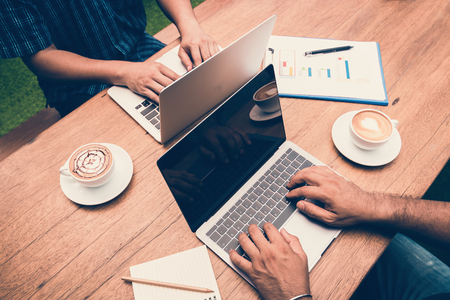 Hands typing on laptop in coffee shopの写真素材
